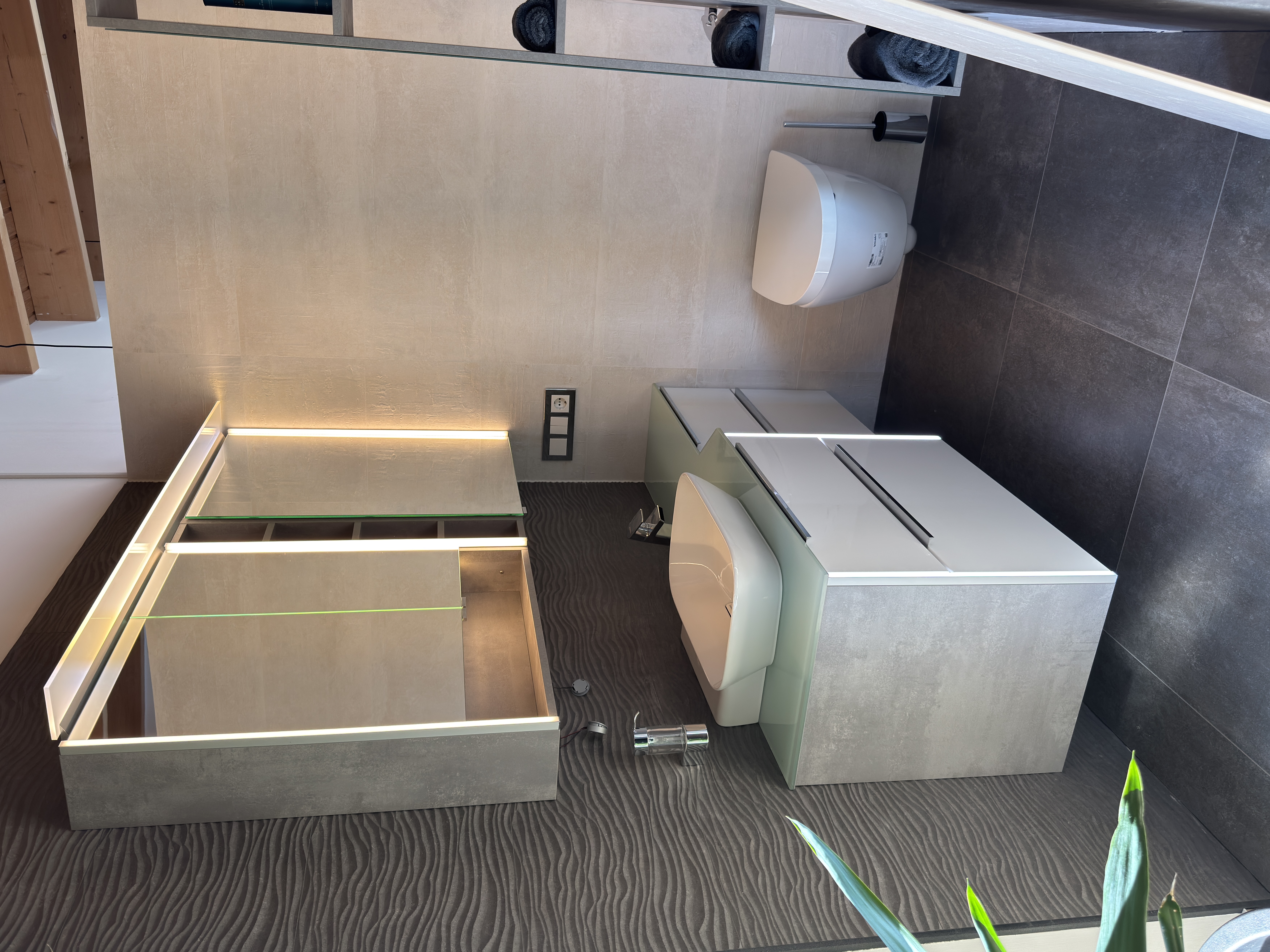 Waschplatz mit weißem Aufsatzbecken, hellem Unterschrank und beleuchtetem Spiegelschrank